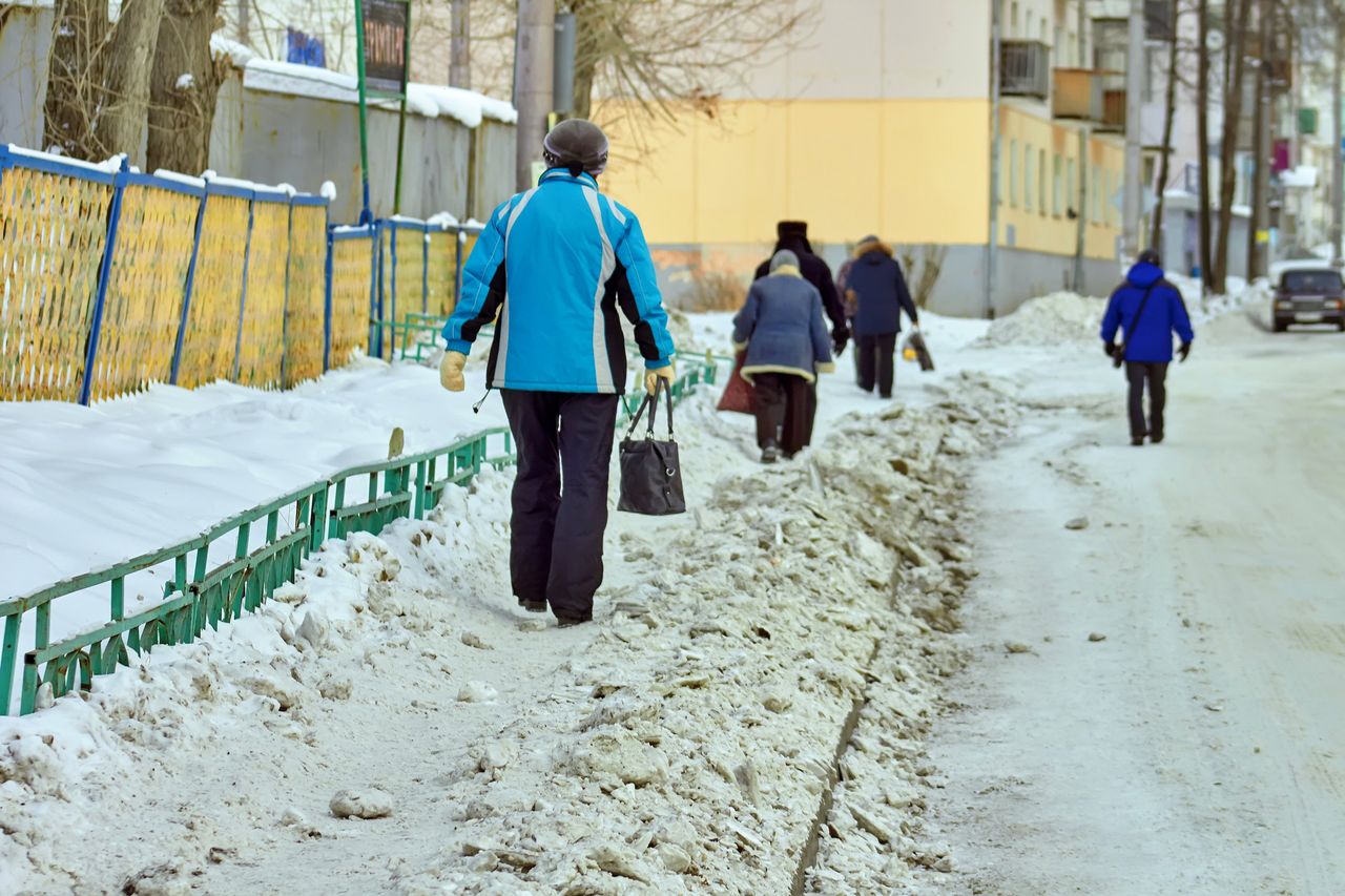 Засыпанный снегом тротуар возле трампарка вынуждает горожан ходить по проезжей части