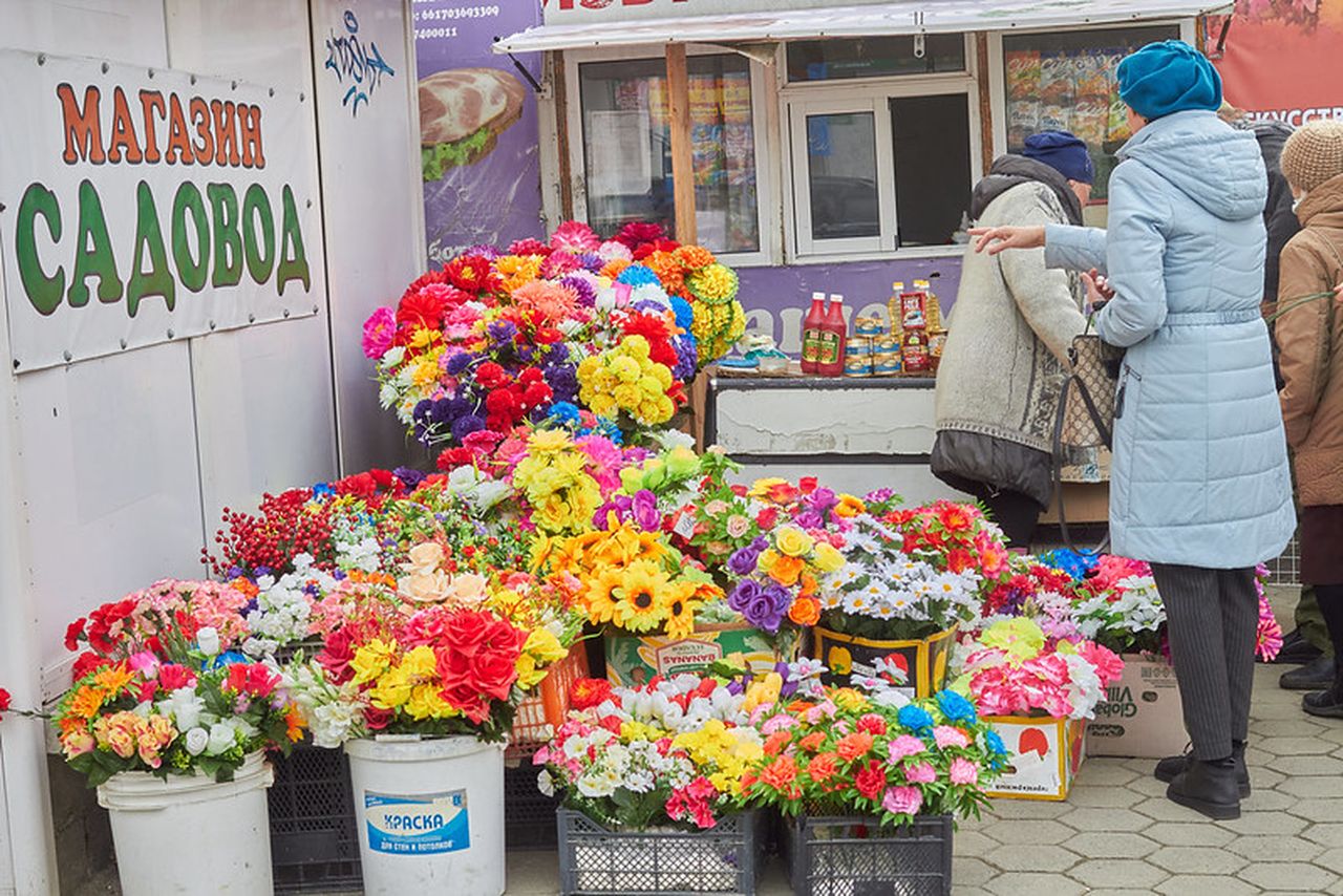 Какими цветами торгуют. Бабушка продает цветы. Бабушка торгует цветами. Торговля искусственными цветами на улице. Смоленская ярмарка искусственных цветов.
