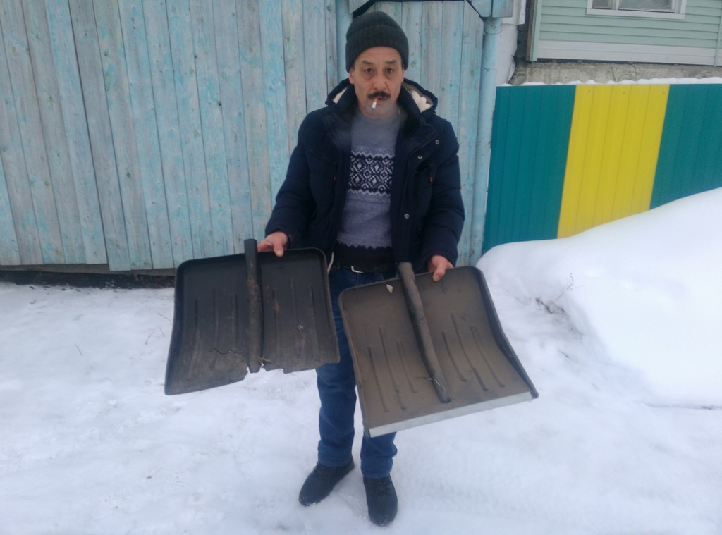 Сабир Золотарев показывает лопаты, которые сломал в этом году при уборке снега, оставшегося после расчистки дорог на подъезде к его дому. Фото: Алеся Копылова, "Вечерний Краснотурьинск". 