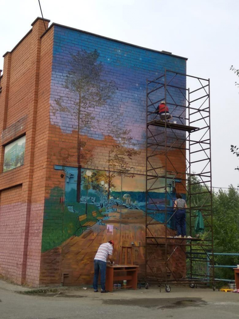 Александр Устинов (в светлой полосатой футболке) лично участвует в росписи стены. Фото: читатель "Вечерки"