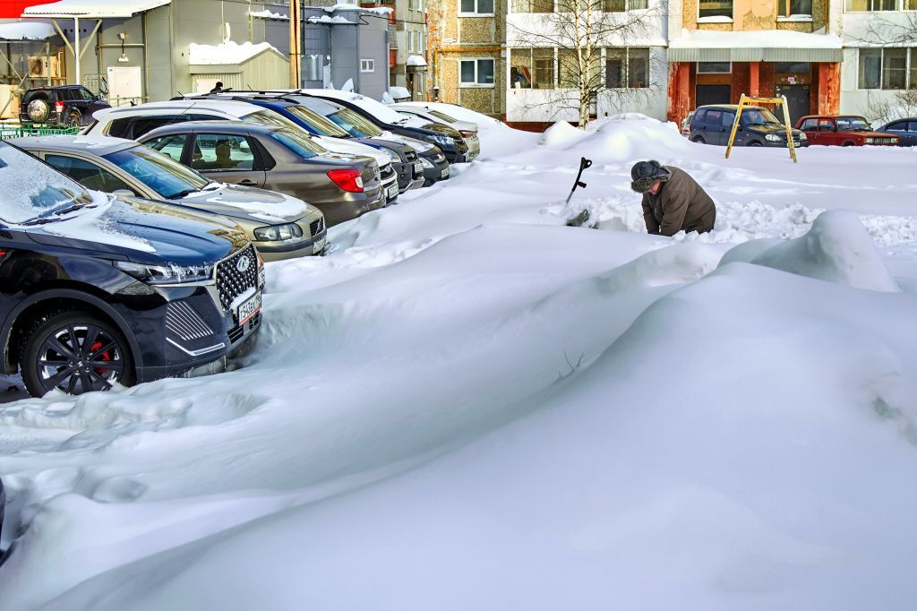 Анатолий сам откапывает для себя и соседей скамейку. Фото: Вадим Аминов, «Вечерний Краснотурьинск»
